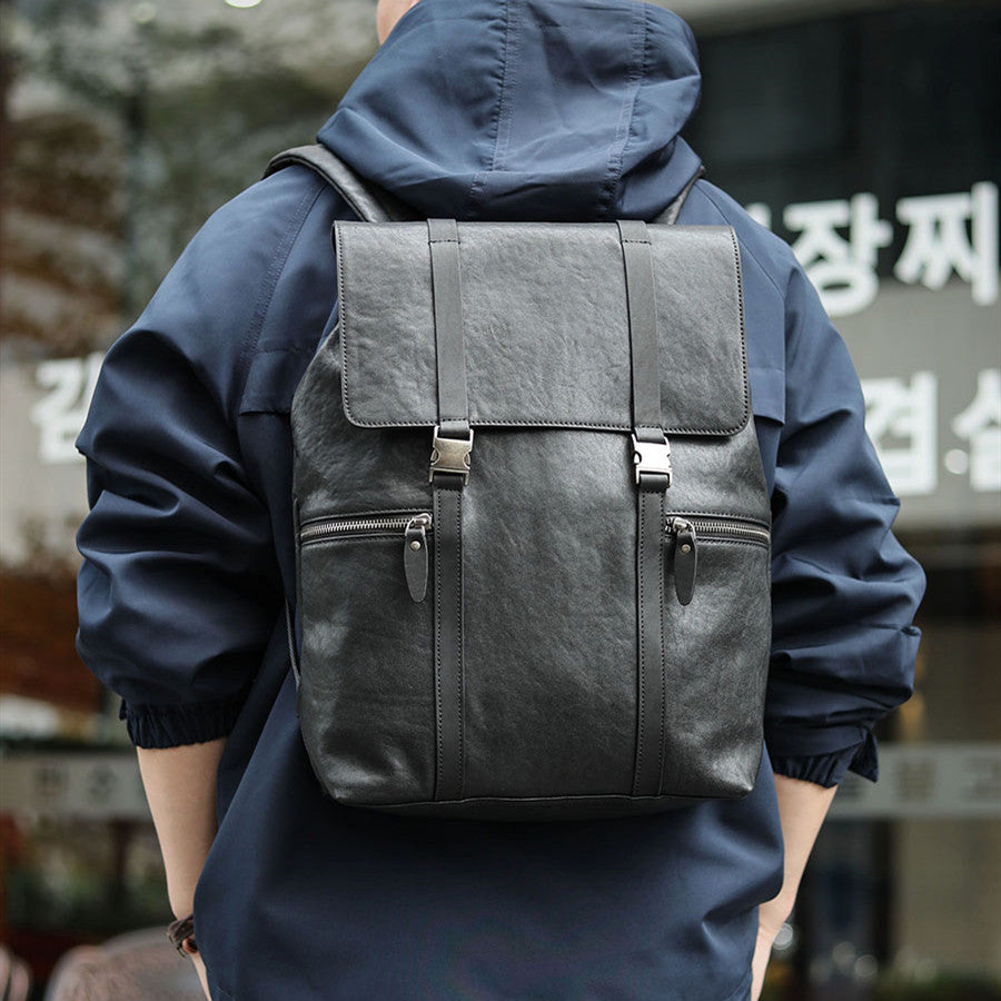Person wearing a dark gray backpack with a blurred background