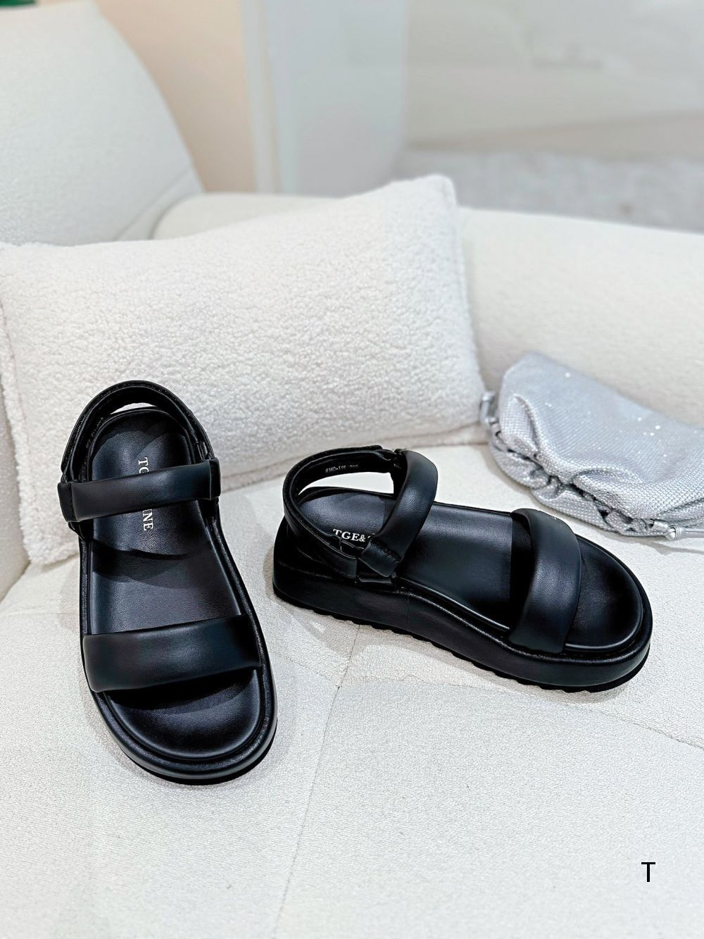 Black sandals on a light-colored surface with a blurred background