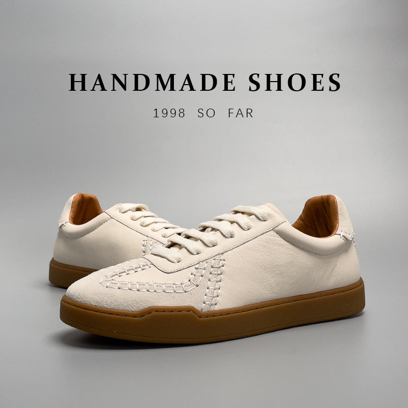 Pair of handmade shoes with brown soles on a gray background, featuring the text 'Handmade Shoes 1998 So Far'.