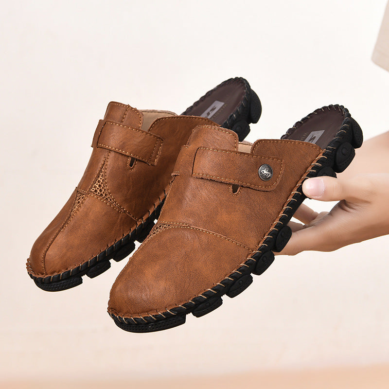 Brown leather shoes with black soles held by a hand on a beige background