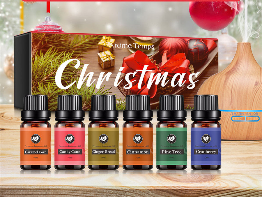 16 Theme Atmosphere Flameless Essential Oil Sets with six festive scents including caramel corn and candy cane on wooden table.