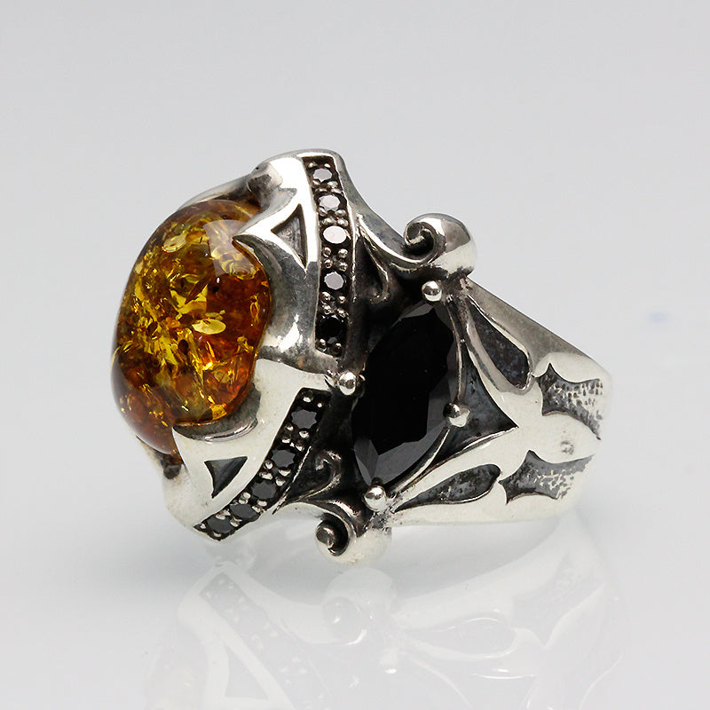 Silver ring with amber stone on a light gray background