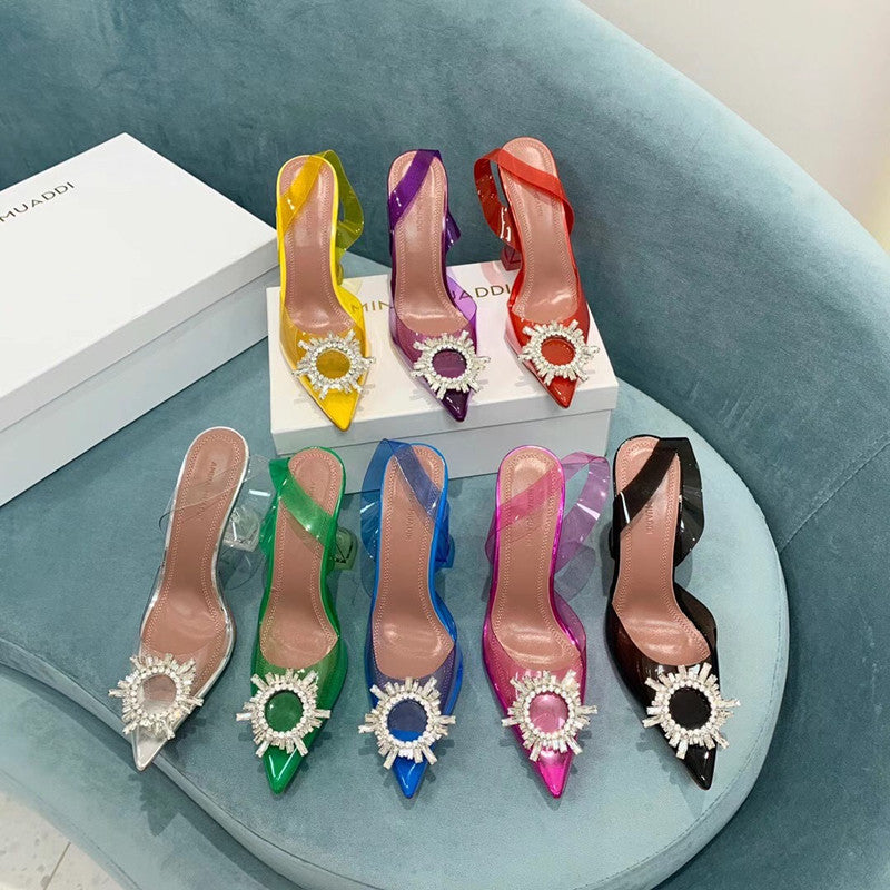 Colorful high-heeled shoes with decorative embellishments on a light blue surface.