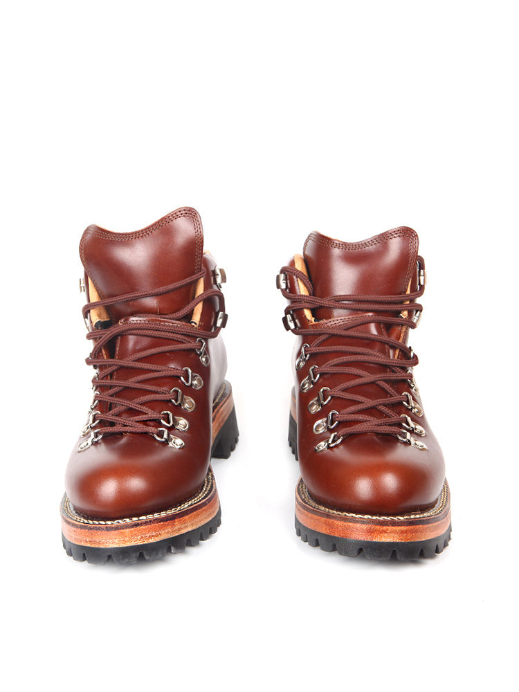 Pair of brown leather hiking boots with orange soles on a white background