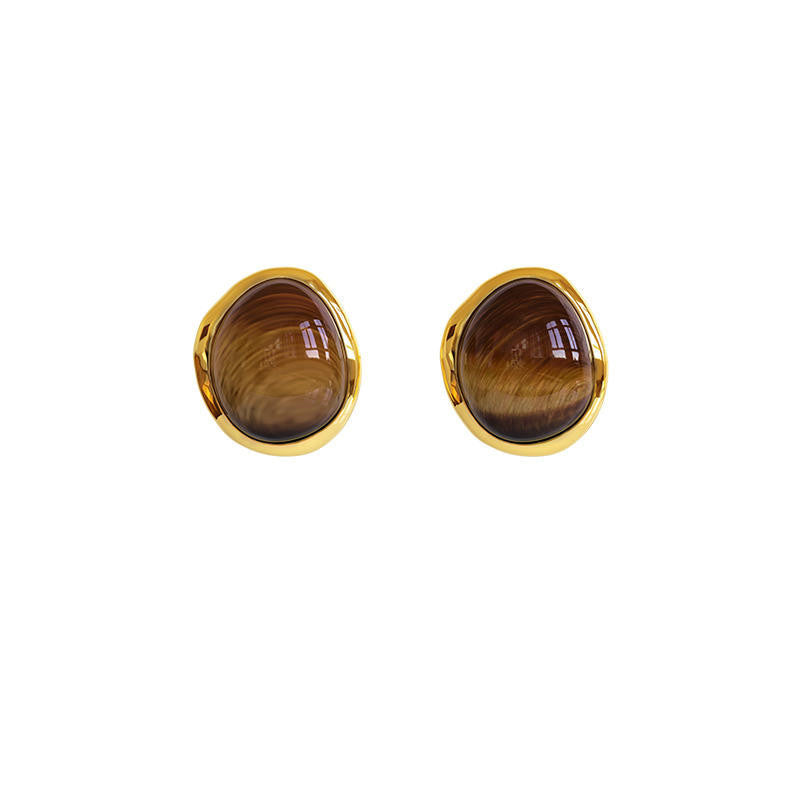 Pair of gold-framed brown oval earrings on a white background