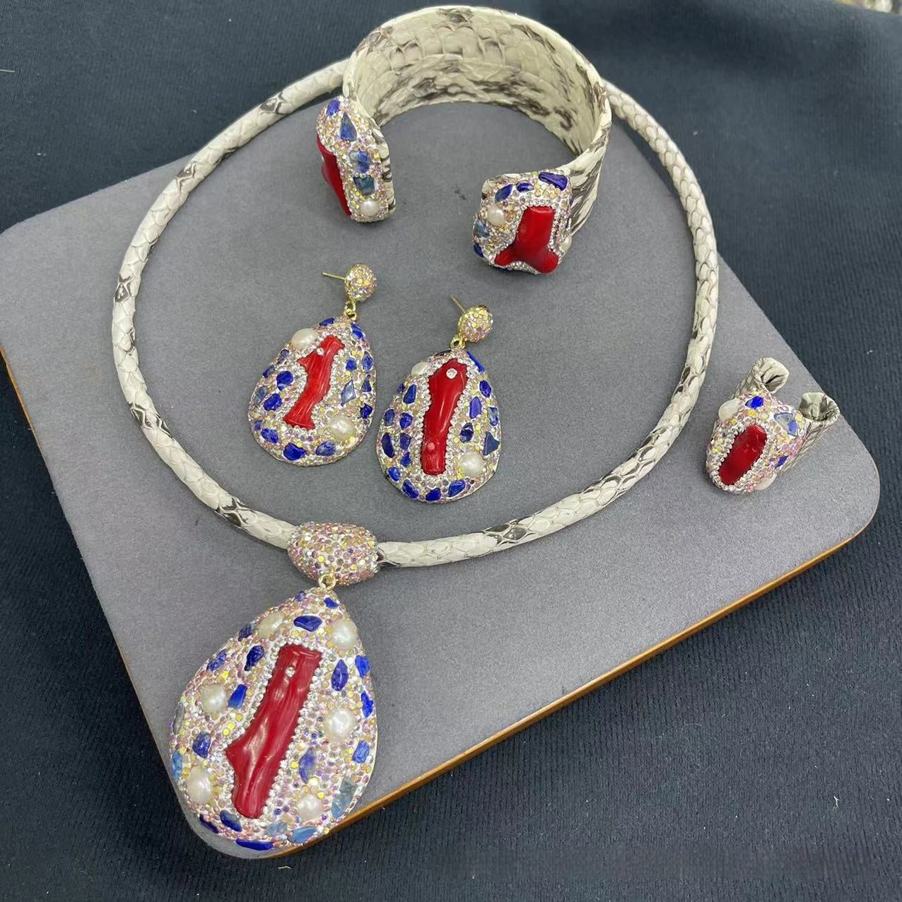Jewelry set with necklace, earrings, and bracelet on a gray surface