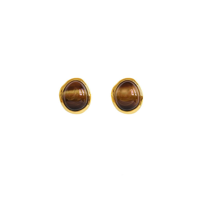Pair of gold earrings with tiger's eye stones on a white background