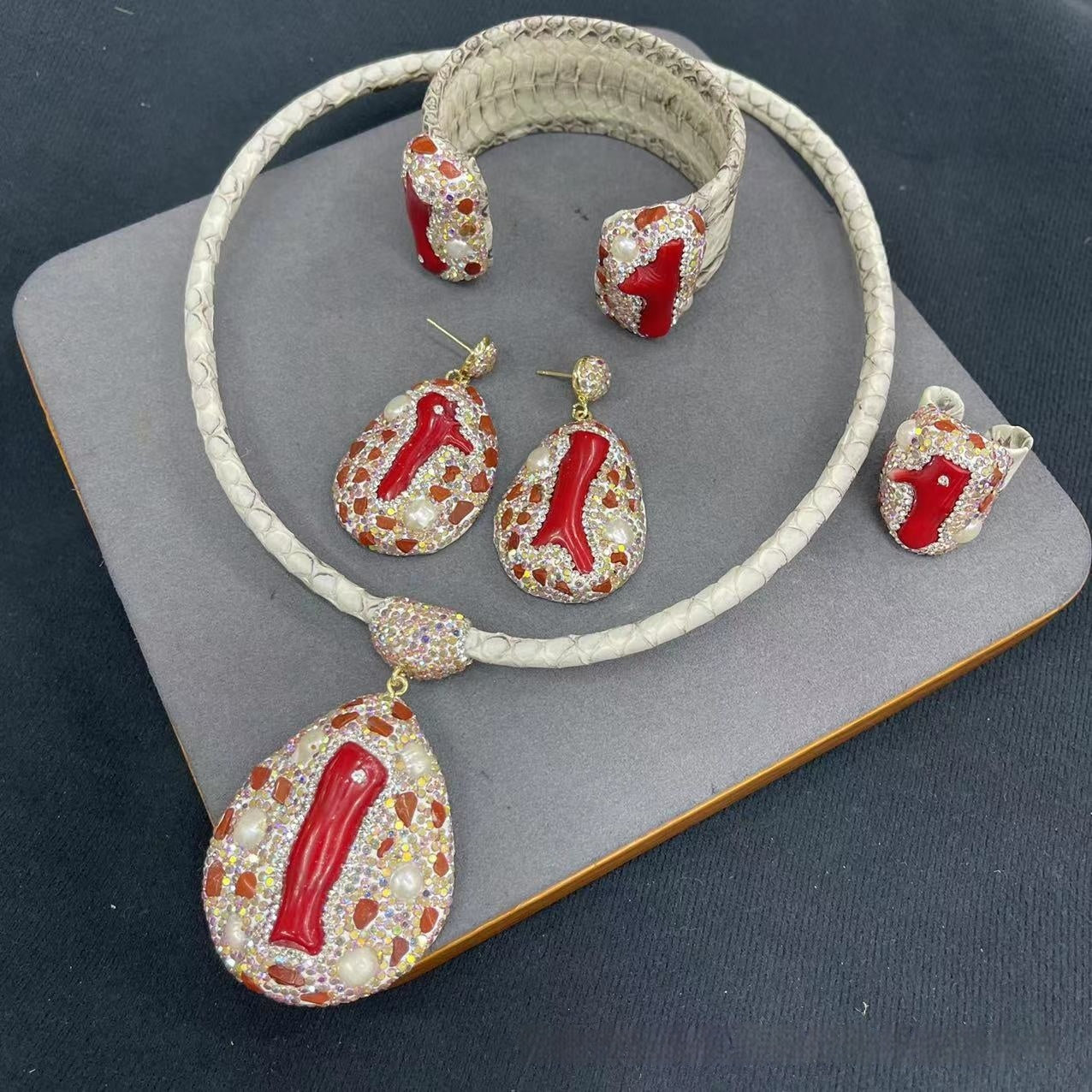 Jewelry set with necklace, bracelet, and earrings on a gray surface