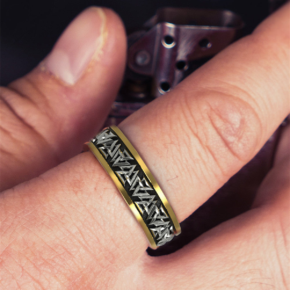 Gold and silver ring on a finger with a blurred background