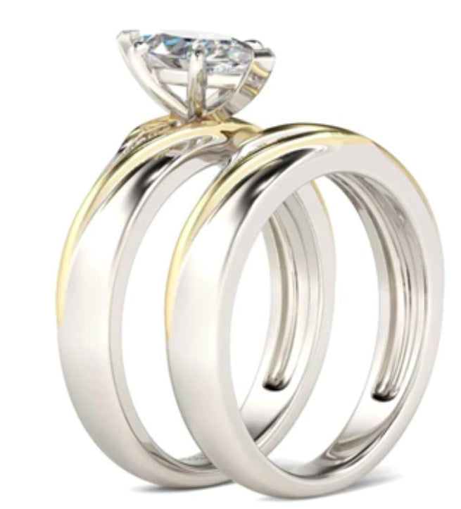 Two wedding rings, one gold and one silver, on a white background