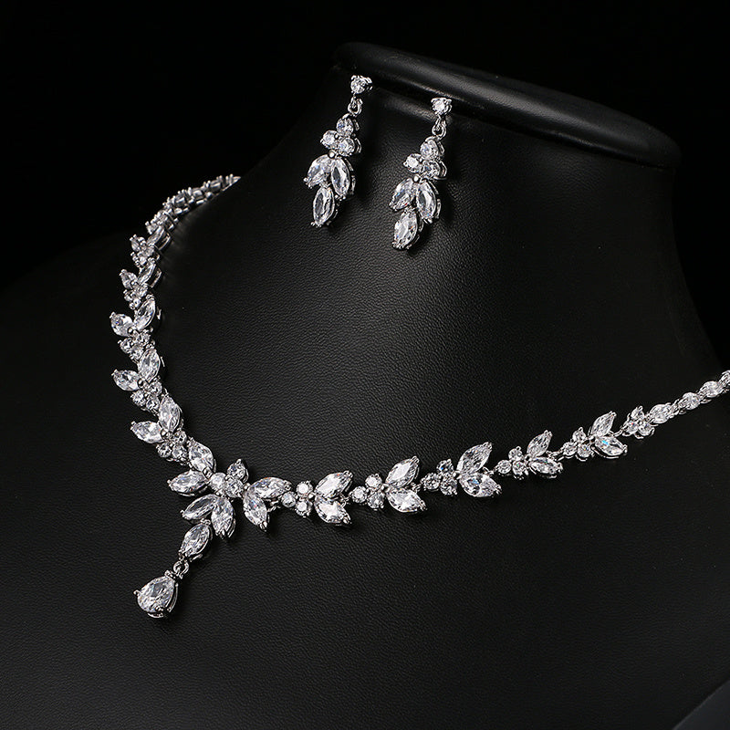 Silver necklace and earrings set on a black background
