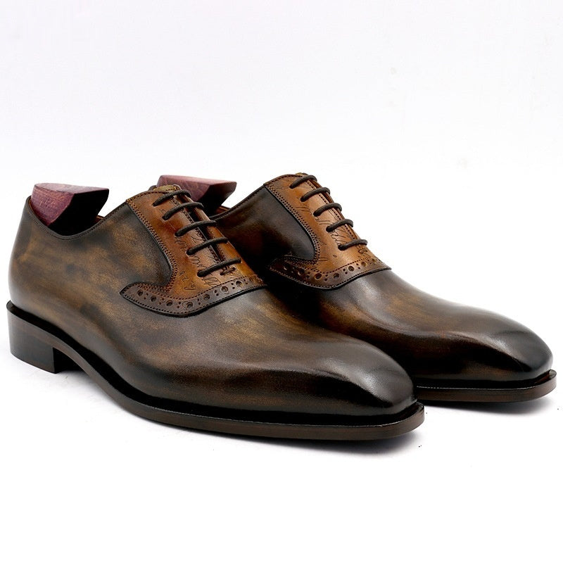 Pair of brown leather dress shoes on a white background