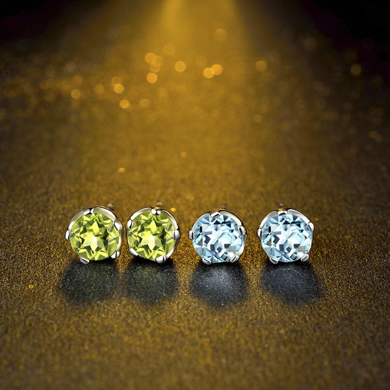 Four gemstone earrings on a gold and black textured background