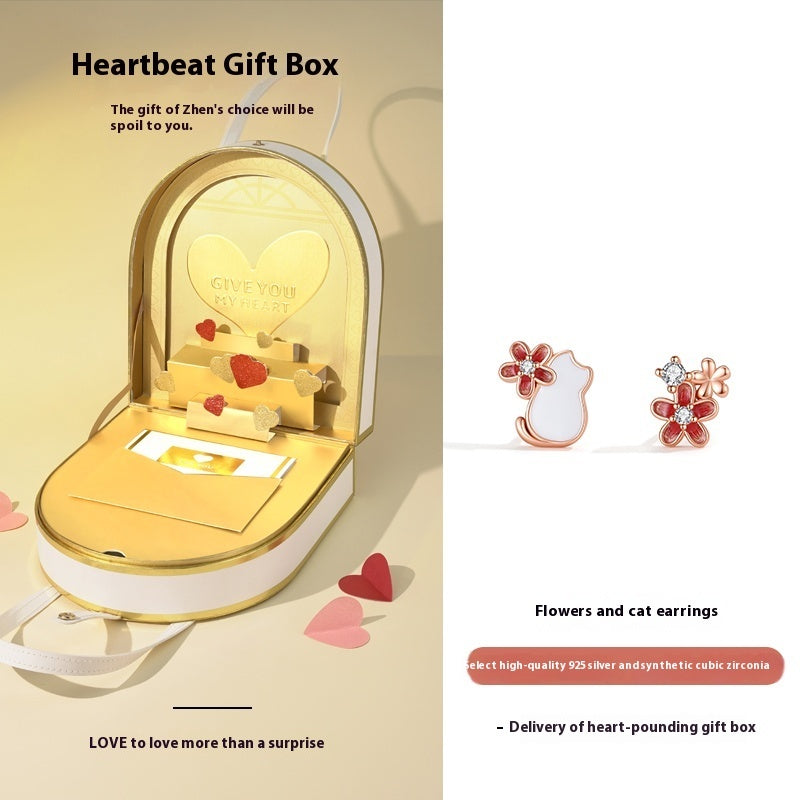Heartbeat gift box with flowers and cat earrings on a beige background