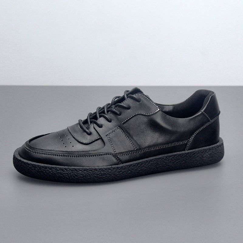 Black leather sneaker on a gray background