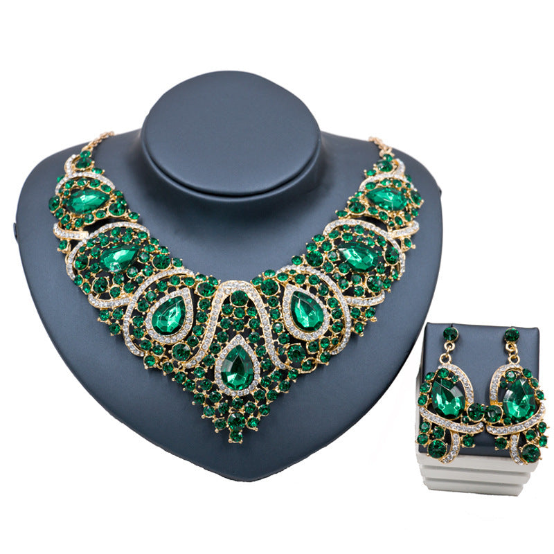 Green gemstone necklace and earrings on a gray stand