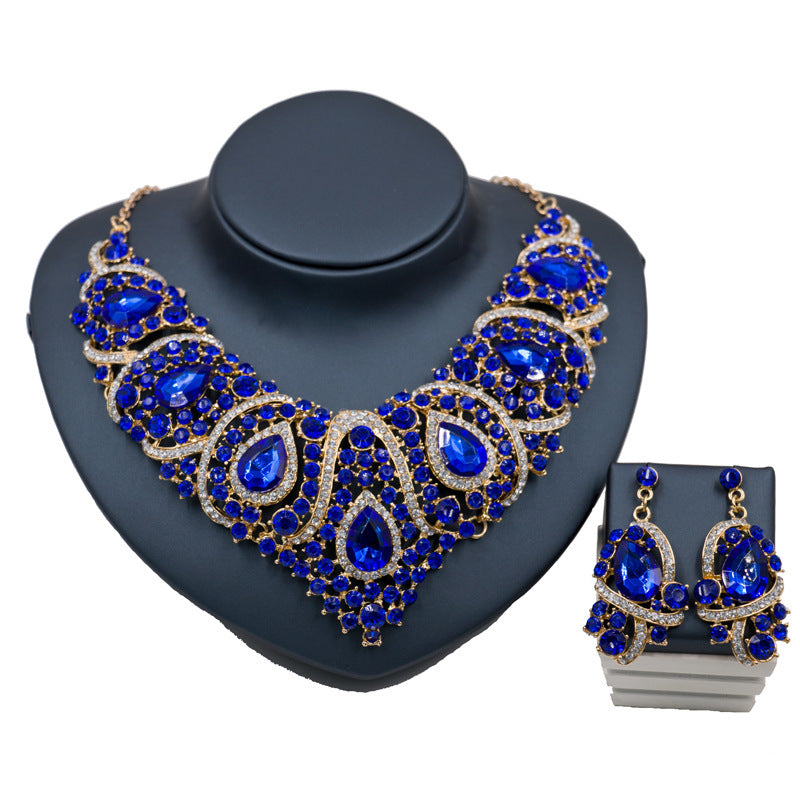 Jewelry set with blue gemstones on a dark gray stand
