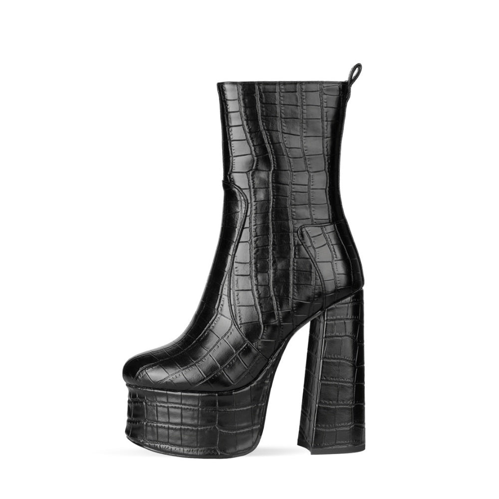 Black platform boot with crocodile texture on a white background