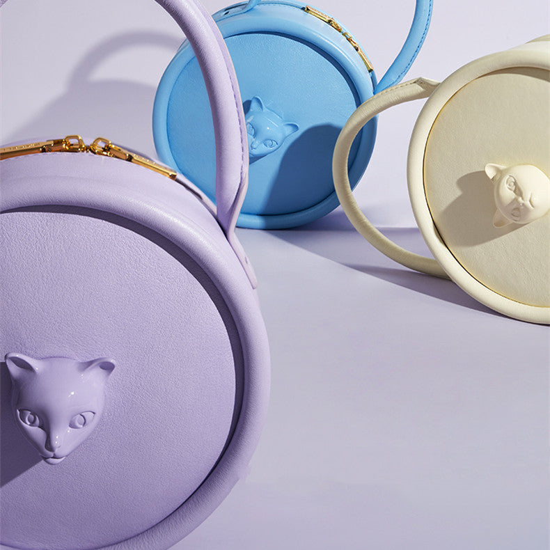 Three colorful containers with animal face lids on a light purple background
