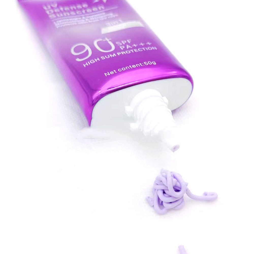 Tube of sunscreen with a white applicator on a white background