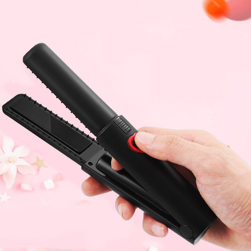 Black hair straightener held by a hand with a pink floral background