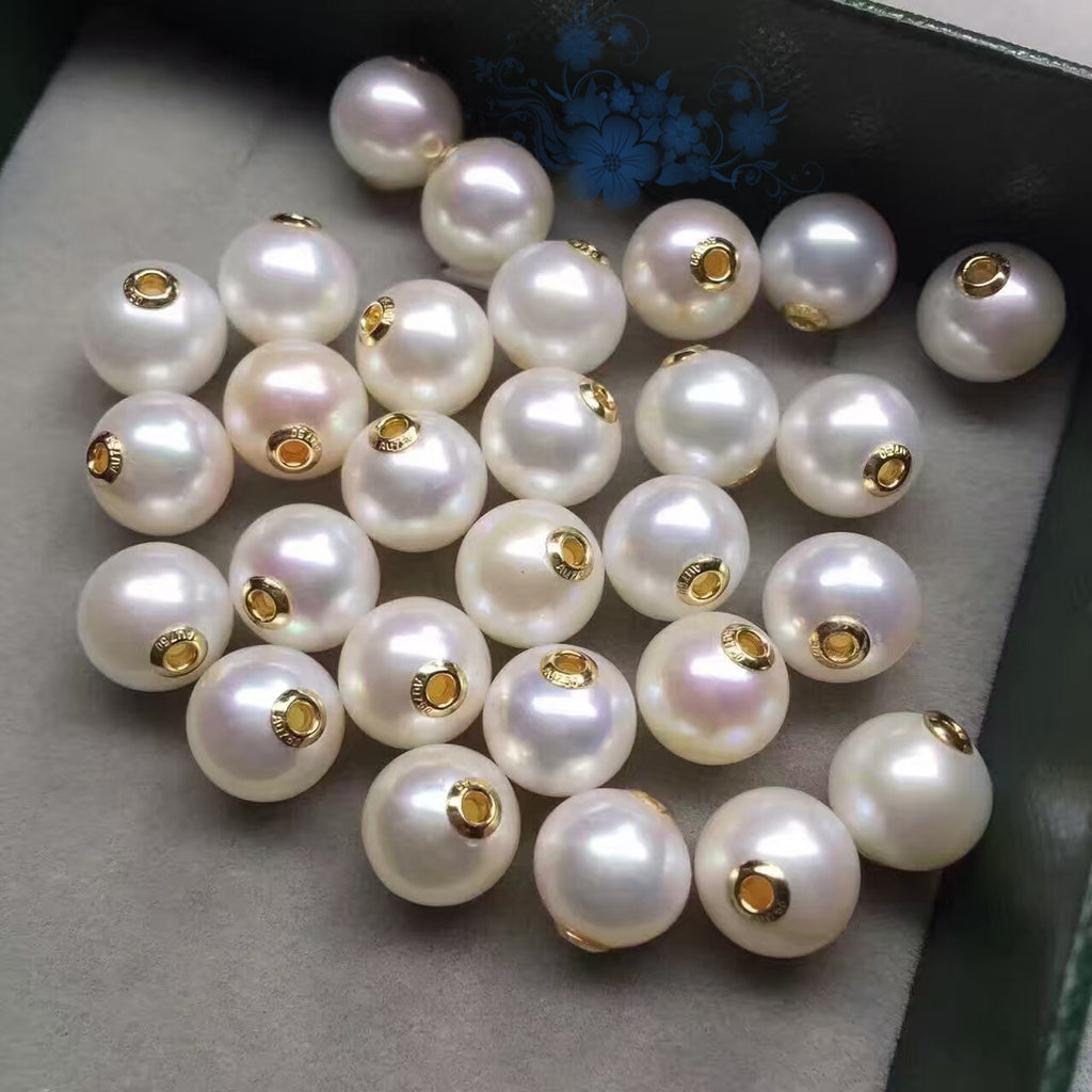 White pearls with gold clasps on a gray surface