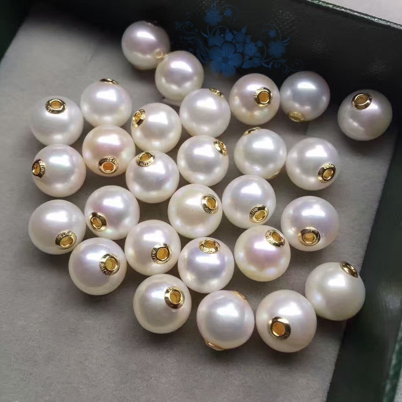 White pearls with gold clasps on a gray surface