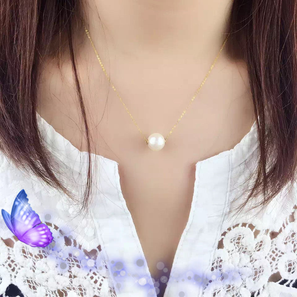 Pearl necklace worn by a person with a white lace top and a purple butterfly graphic.