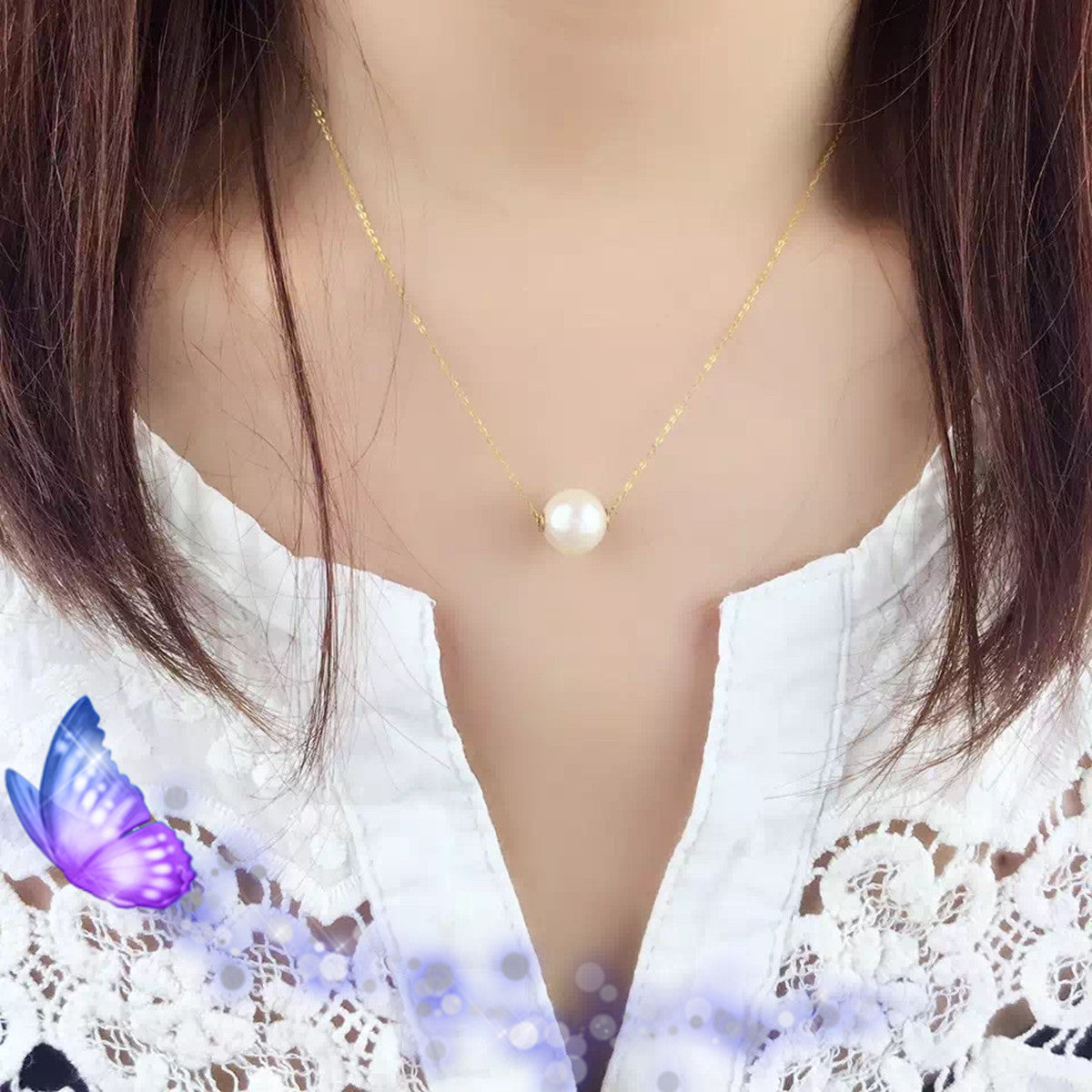 Pearl necklace worn by a person with a white lace top and a purple butterfly graphic.