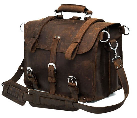 Brown leather satchel bag with metal buckles on a white background