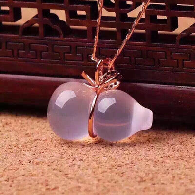 Necklace with a pendant shaped like a white flower on a textured surface