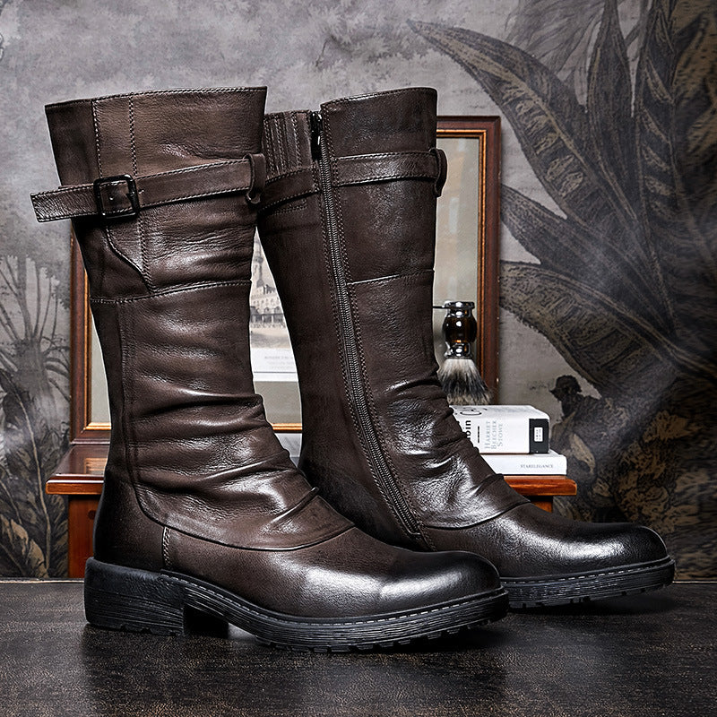 Pair of brown leather knee-high boots with buckles on a textured surface.