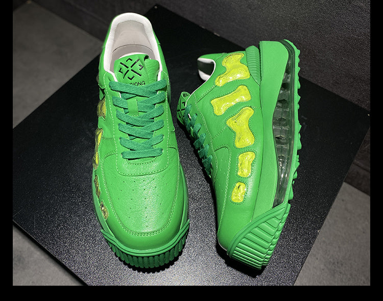 Green sneakers with yellow accents on a black surface