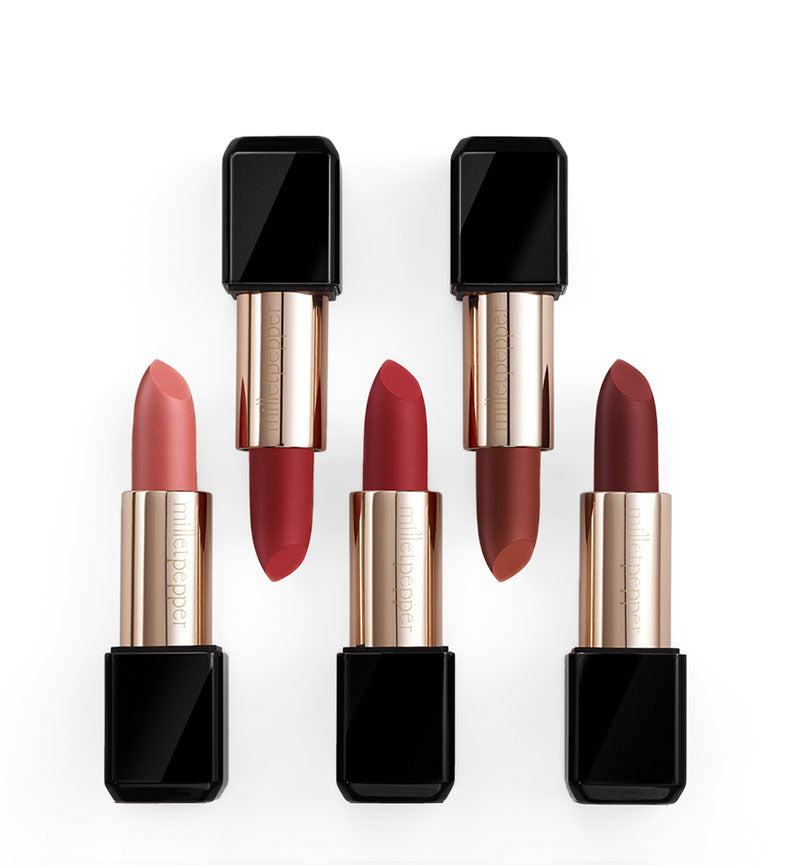 Set of four lipsticks with black and rose gold cases on a white background