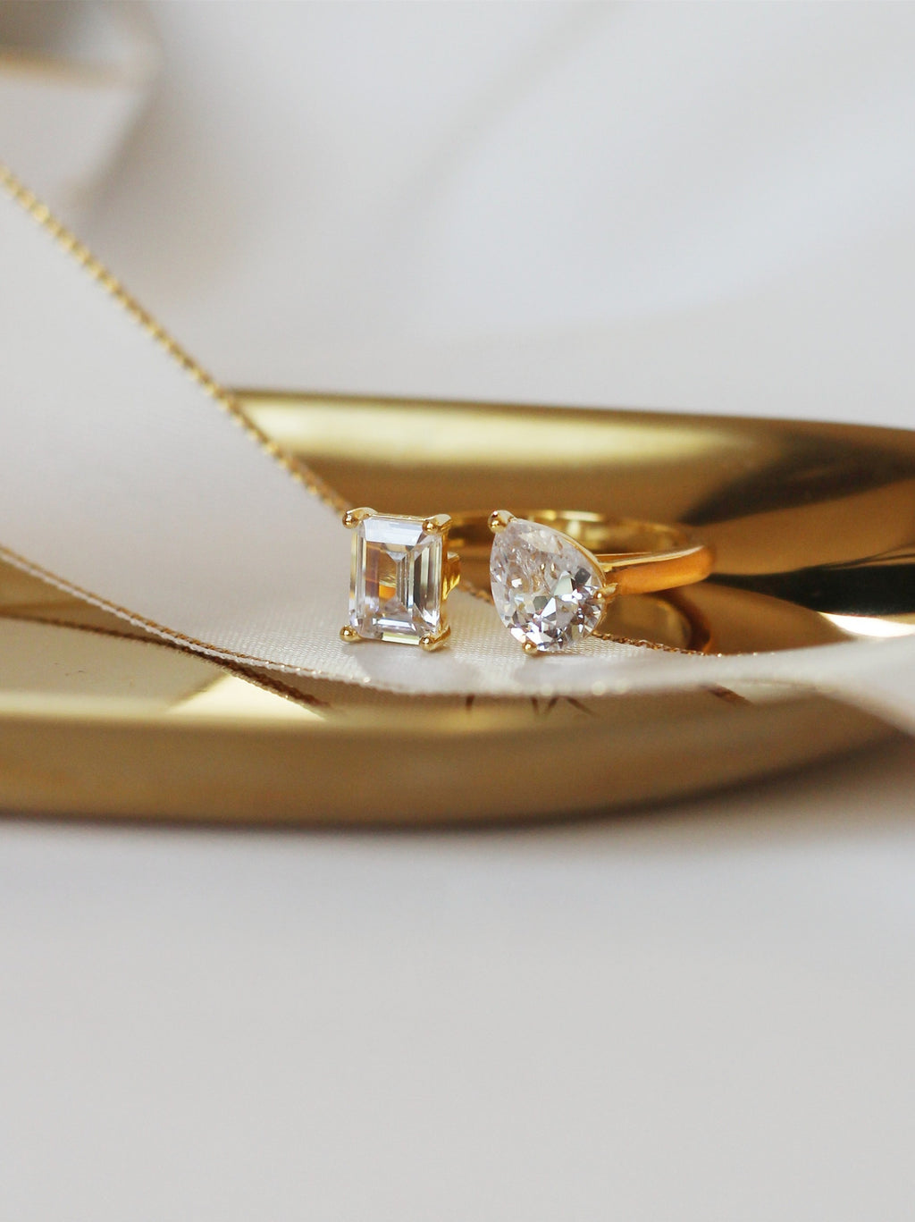 Gold ring with two diamond stones on a white background
