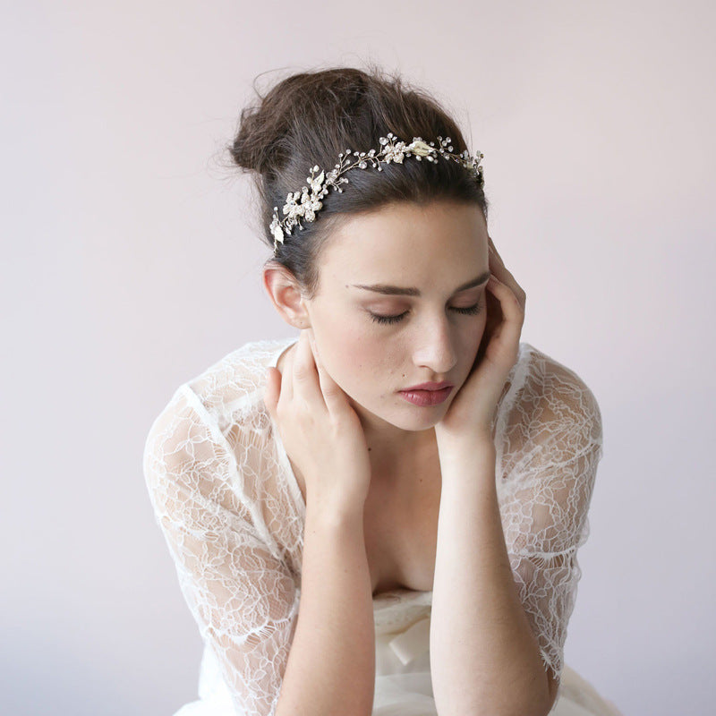 Woman wearing a delicate headpiece with a plain background