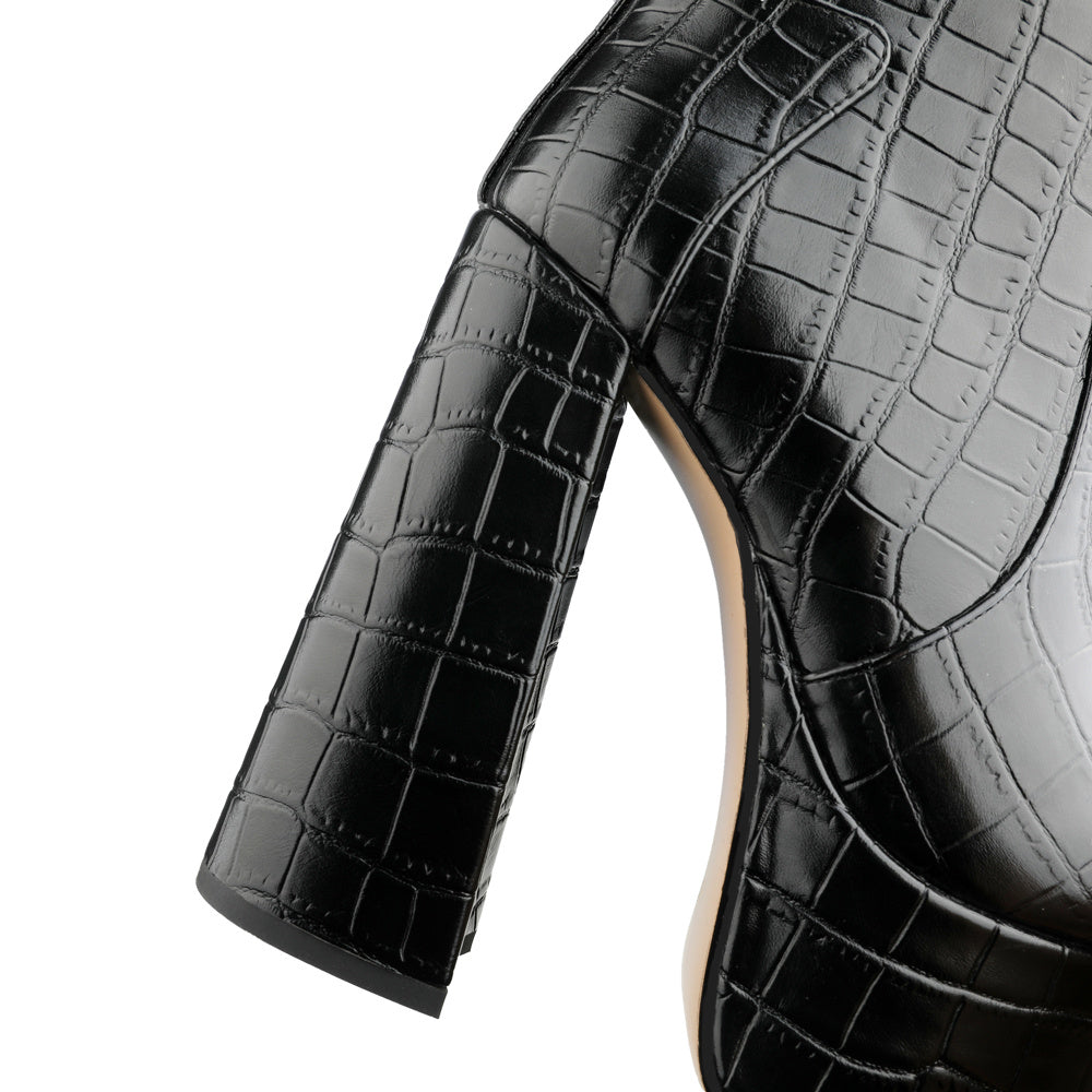 Black crocodile-patterned high-heeled shoe on a white background