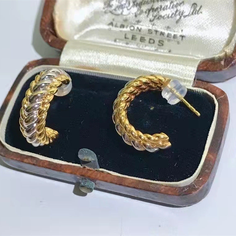 Pair of gold hoop earrings in an open jewelry box with 'Albion Street Leeds' branding.