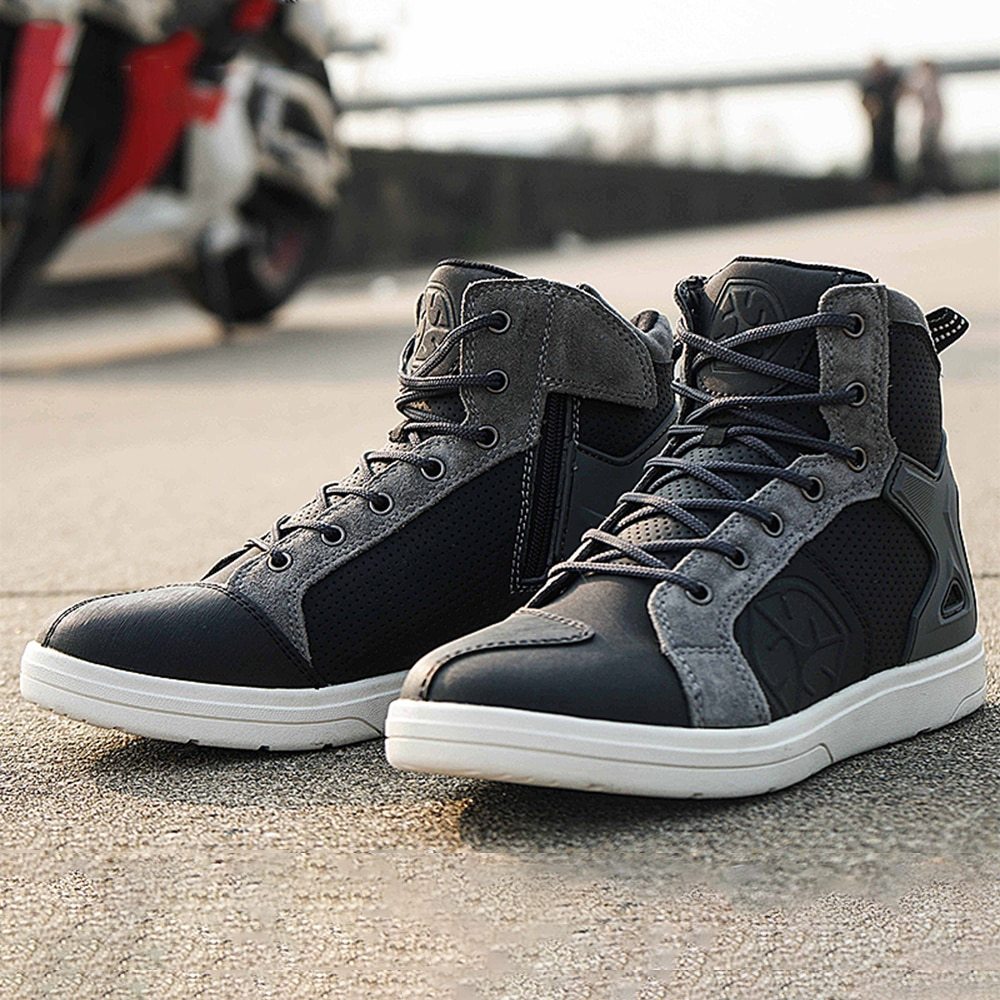 Black and gray high-top sneakers on a concrete surface with a blurred background