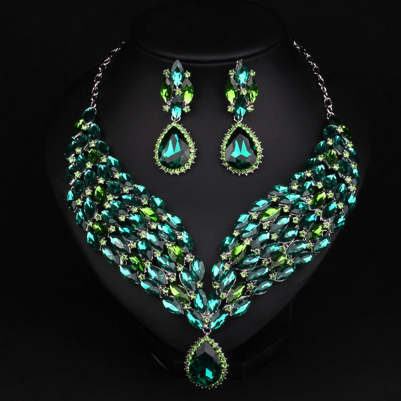 Green gemstone necklace and earrings on a black background
