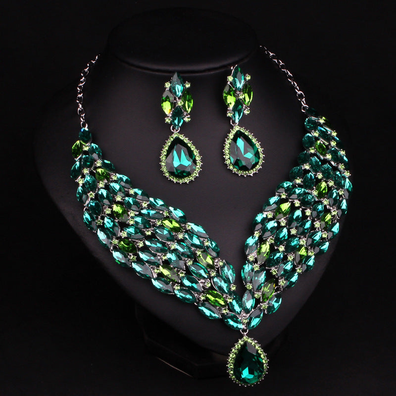 Green gemstone necklace and earrings on a black background