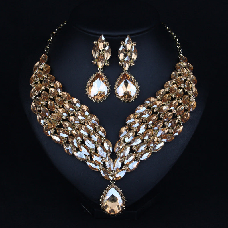 Gold and crystal necklace and earrings set on a black background