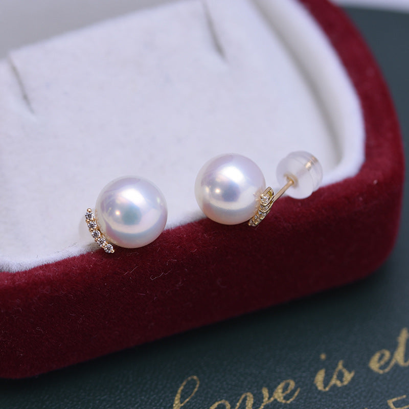 Pearl earrings on a red velvet cushion with 'love is et' text.