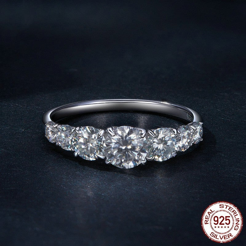 Silver ring with diamonds on a dark background, featuring a 'Real Sterling Silver 925' stamp.