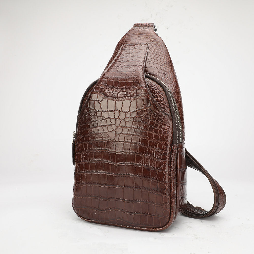 Brown crocodile-patterned sling bag on a white background