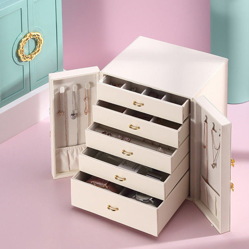 White jewelry box with open drawers on a pink surface