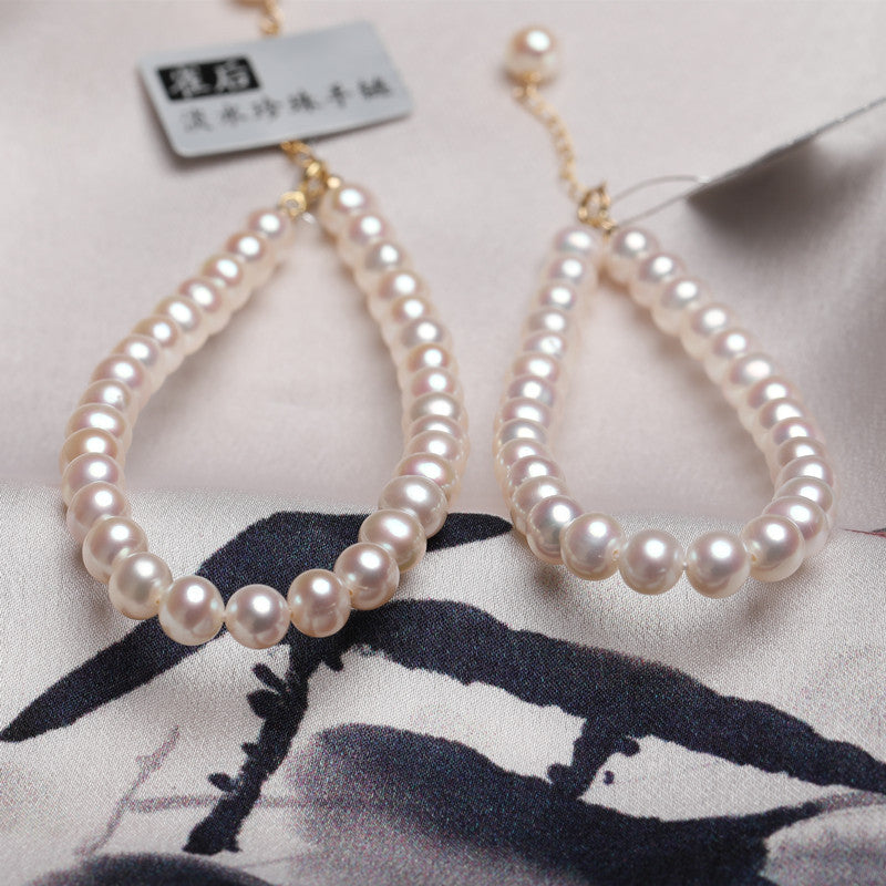 Pair of pearl earrings on a floral fabric background