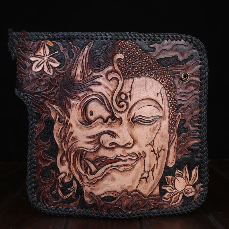 Leather pouch with intricate face design and floral patterns on a dark background
