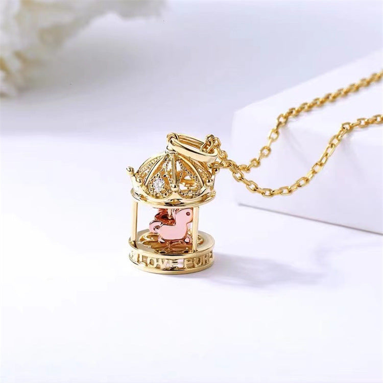 Gold necklace with a birdcage pendant on a white background