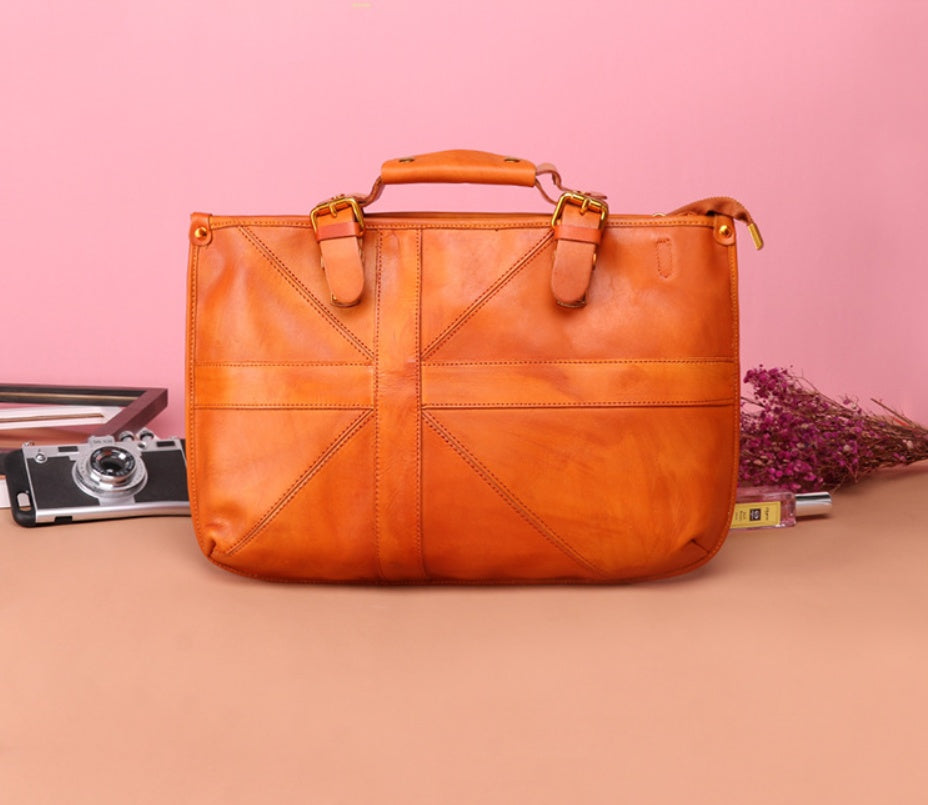 Brown leather bag on a pink background with a camera and flowers.